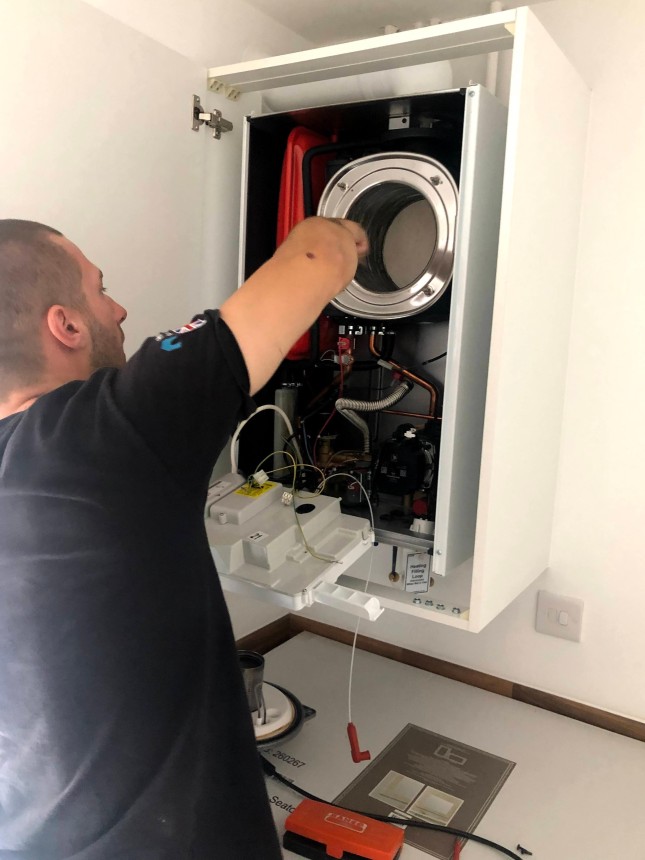 Mitch cleaning a heat exchanger on a Baxi boiler